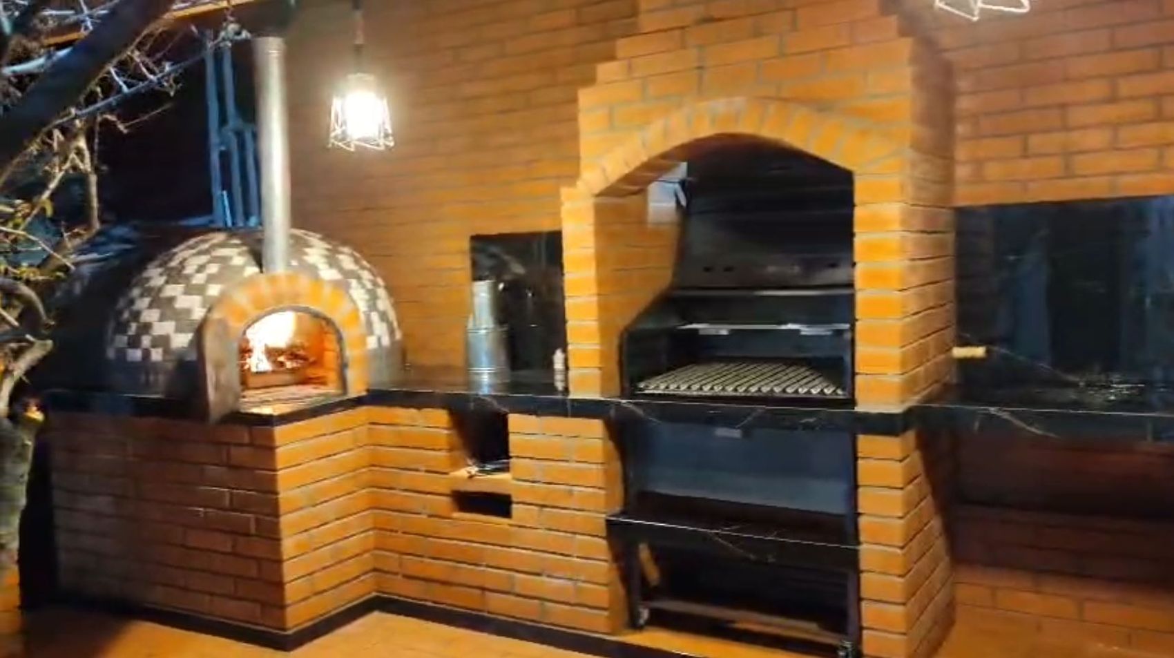 Parrilla y horno de ladrillo encendidos de noche