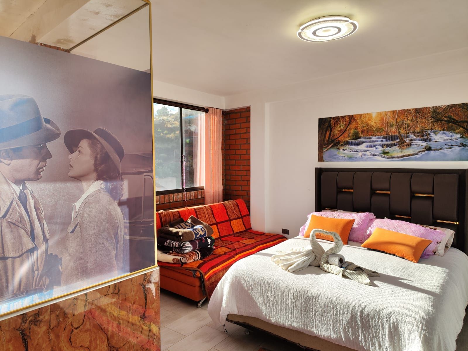 Suite VIP con cama grande y cojines naranjas